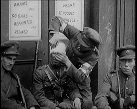 Irish Soldiers Sitting in the Street and Tending to Their Injuries from Fighting in Dublin, 1922. Creator: British Pathe Ltd.