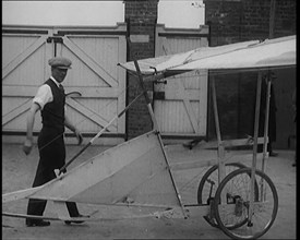 Male Civilian Carrying a Small Pedal Powered Flying Machine and Trying to Demonstrate It in..., 1929 Creator: British Pathe Ltd.