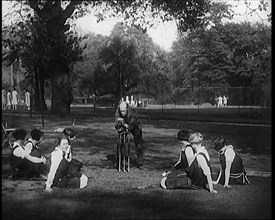 Male Civilian Demonstrating How to Set up a Cricket Wicket to a Group of Young Female..., 1920. Creator: British Pathe Ltd.