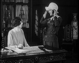 Female Civilian Trying a Hat in Front of Another Female Civilian, 1920. Creator: British Pathe Ltd.