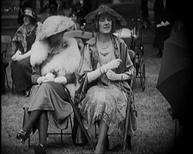 Three Female Civilians Seating Outdoors Wearing Evening Outfits and Hats, 1920. Creator: British Pathe Ltd.