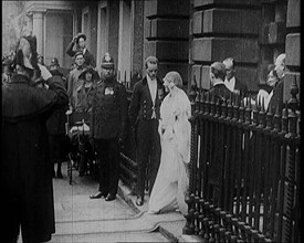 The Duke of York and Lady Elizabeth Bowes-Lyon Emerging from a House on Their Wedding Day, 1920. Creator: British Pathe Ltd.