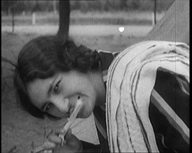 Female Civilian with Dark Hair Brushing Her Teeth Outdoors, 1920. Creator: British Pathe Ltd.