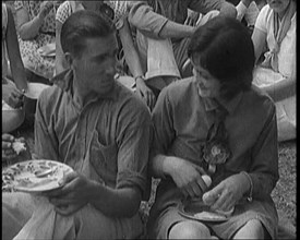 Male Civilian and Female Civilian Enjoying a Picnic Outdoors, 1920. Creator: British Pathe Ltd.