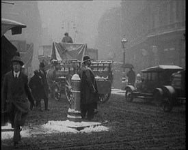 British Civilians Going About their Daily Commute on a Snowy Day on the Streets Watched by..., 1920. Creator: British Pathe Ltd.