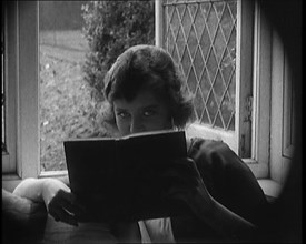 Evelyn Laye CBE, British Actress, Hiding Her Face Behind a Book, 1920. Creator: British Pathe Ltd.