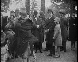 Female Civilian Helping Another Female Civilian to Put on a Coat in Front of a Car and a..., 1920. Creator: British Pathe Ltd.