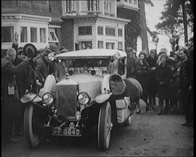 Two Female Civilians Explorers Driving Away in Their Heavily Loaded Car Watched by a Small..., 1920. Creator: British Pathe Ltd.