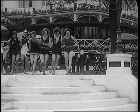 A Group of Young Female Civilians Running down Some Steps Wearing Swimsuits, 1920. Creator: British Pathe Ltd.