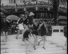 A Group of Young Female Civilians Running down Some Steps Wearing Swimsuits, 1920. Creator: British Pathe Ltd.