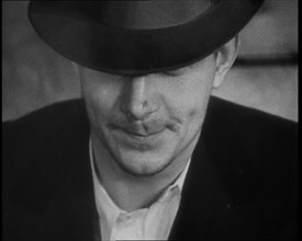 Male American Civilian Wearing a Hat Sitting at a Desk, 1930. Creator: British Pathe Ltd.