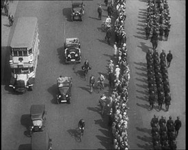 Aerial Shot of Soldiers Marching Down the Road in Front of a Crowd, 1933. Creator: British Pathe Ltd.