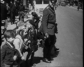 Man in Uniform Helping Young Children Cross the Road, 1933. Creator: British Pathe Ltd.