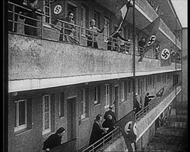 People Waving Flags of the Nazi Party and German Flags of 1867-1918 from Balconies, 1933. Creator: British Pathe Ltd.