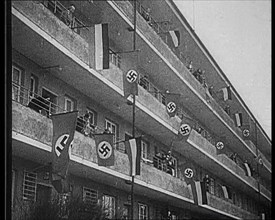 People Waving Flags of the Nazi Party and German Flags of 1867–1918 from Balconies, 1933. Creator: British Pathe Ltd.