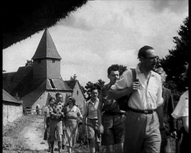 People Hiking with a Church in the Background, 1933. Creator: British Pathe Ltd.