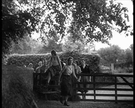 Hikers Climbing over a Gate, 1933. Creator: British Pathe Ltd.