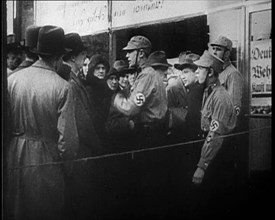 Men in Nazi Uniforms and Civilians Standing Outside a Shop With anti-Jewish Posters on it, 1933. Creator: British Pathe Ltd.