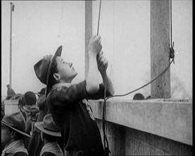 Male Boy Scout Unfurls the Flags of the British Empire, 1924. Creator: British Pathe Ltd.