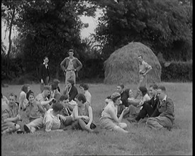 A Large Group of Hikers Having Drinks in a Field Beside a Haystack, 1931. Creator: British Pathe Ltd.