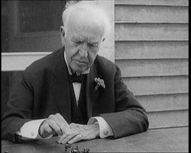 Thomas Edison Sitting at an Outside Desk and Operating a Morse Code Sender, 1921. Creator: British Pathe Ltd.