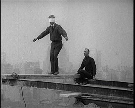 Blindfolded Man Walking Across a Plank Suspended from Iron Girders High Above the City Streets, 1921 Creator: British Pathe Ltd.