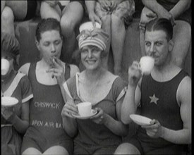 British People Sitting Around and Drinking Cups of Tea While Wearing Bathing Suits at the.., 1920. Creator: British Pathe Ltd.