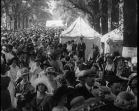 People Gathering and Relaxing at a Fairground Between Marquees and Balloons, 1920. Creator: British Pathe Ltd.