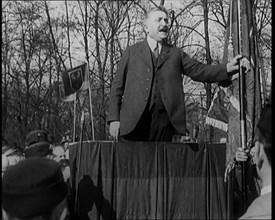 A Male Civilian Makes a Speech from a Stand in Front of a Crowd of Male Civilians Carrying..., 1924. Creator: British Pathe Ltd.