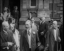 King George V Accompanied by a Group of Officials Emerging from a Building , 1924. Creator: British Pathe Ltd.