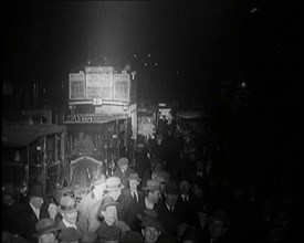 Buses and Crowds of People on a Busy London Street at Night, 1920s. Creator: British Pathe Ltd.