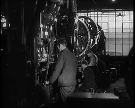 Male Civilians Working Large Presses in a Factory, 1931. Creator: British Pathe Ltd.