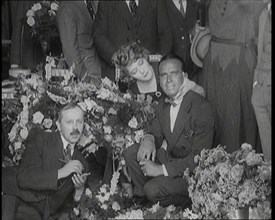 Mary Pickford and Douglas Fairbanks Senior Sitting Together Amongst a Bed of Flowers in Paris, 1920. Creator: British Pathe Ltd.