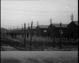 Irish Prisoners Walking Across a Barbed Wire Fenced Prison Ground, 1921. Creator: British Pathe Ltd.