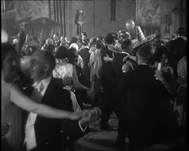 A Crowd of People Dancing at a Fancy Dress Party Whilst a Band is Playing on the Stage, 1920s. Creator: British Pathe Ltd.