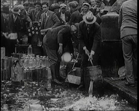 Prohibition Scenes in the United States of America. Men Smashing Bottles of Alcoholic..., 1920. Creator: British Pathe Ltd.