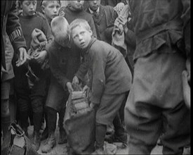 Children Dressed in Scruffy Clothes Gathering Fire Wood Into Sacks, 1920. Creator: British Pathe Ltd.