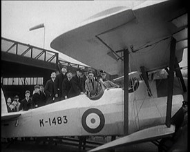 An RAF Officer Showing a Group of Male Children His Aeroplane, 1931. Creator: British Pathe Ltd.