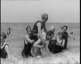 Group of Four Female Civilians and One Male Civilian in Bathing Suits Playing in the Sea..., 1924. Creator: British Pathe Ltd.