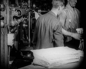 Male Printers Pulling Newspapers Off the Printing Press, 1921. Creator: British Pathe Ltd.