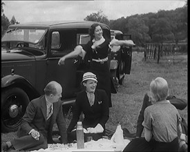 Male and Female Civilians Having a Picnic Beside a Car, 1931. Creator: British Pathe Ltd.