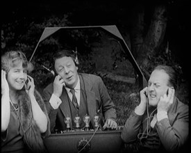 Comedian Harry Tate Sitting With One Female Civilian and One Male Civilian Listening to The..., 1924 Creator: British Pathe Ltd.