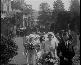 Bride and Groom Walking Through Gardens of Wedding Venue, Followed by Bridesmaids, as Their..., 1921 Creator: British Pathe Ltd.