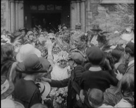 British Bride and Groom Exiting a Church After Their Wedding Ceremony. Guests Are Throwing..., 1921. Creator: British Pathe Ltd.