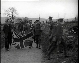 British Soldiers Marching a Sinn Fein Supporter Down a Country Lane, Forcing Him to Bear..., 1920. Creator: British Pathe Ltd.