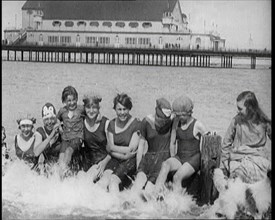 Women and Children Sitting on a Groyne, Splashing With Their Feet on a British Beach, 1920. Creator: British Pathe Ltd.