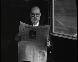 A Bald Man Wearing Spectacles Reading 'The Daily Telegraph' in the Carriage of a Train..., 1938. Creator: British Pathe Ltd.