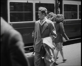 A Man in a Casual Suit and Carrying a Coat and Suitcase Walking Along a Platform Having..., 1938. Creator: British Pathe Ltd.