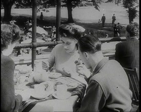 A Close up of Two Women and a Man Having Food and Drink on the Roof Terrace at  the Tea..., 1939. Creator: British Pathe Ltd.