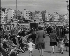 British Holidaymakers Walking Along the Promenade or Sitting on Deckchairs at Brighton..., 1938. Creator: British Pathe Ltd.